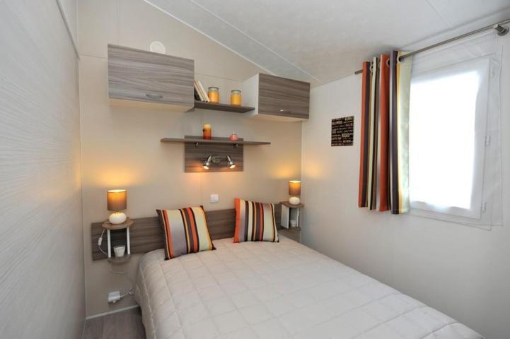 une chambre avec un lit dans une pièce avec une fenêtre dans l'établissement Camping de Brouël, à Ambon