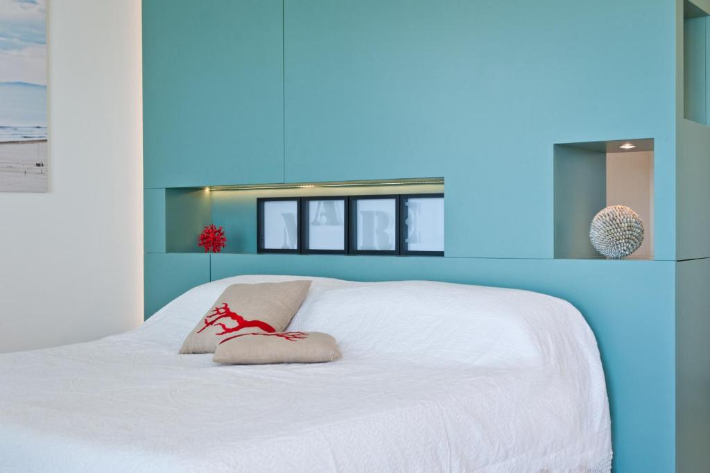 - un lit blanc avec une paire de chaussons dans l'établissement Hotel Torremaura, à Milano Marittima 46 autres photos