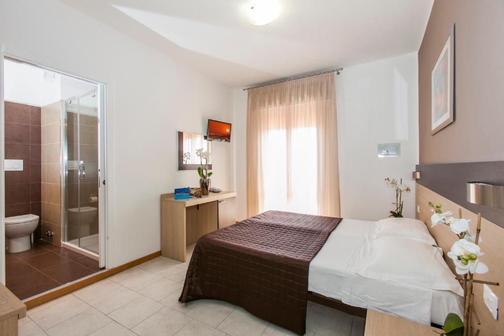une chambre avec un lit et une salle de bain avec douche dans l'établissement Hotel Gardenia, à Lido di Jesolo