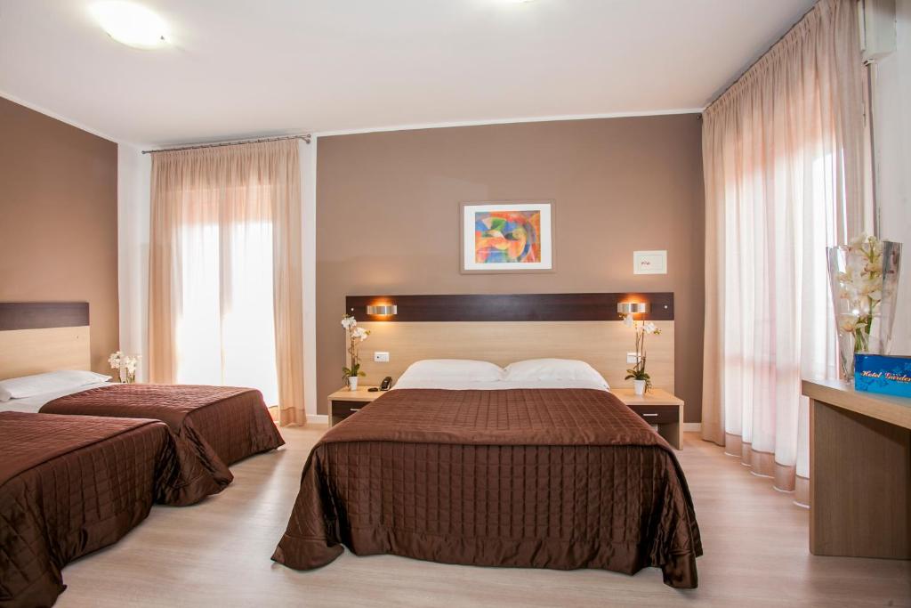 une chambre d'hôtel avec deux lits et une fenêtre dans l'établissement Hotel Gardenia, à Lido di Jesolo 67 autres photos