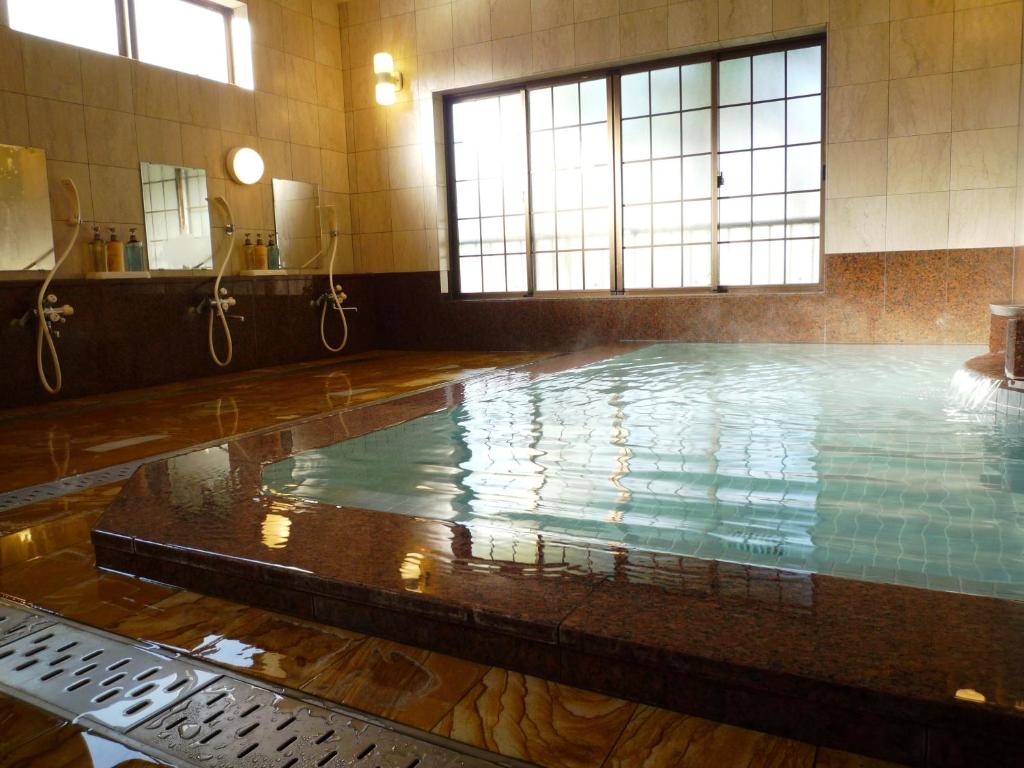 - une grande piscine dans un bâtiment avec piscine dans l'établissement Takanoya, à Yuzawa