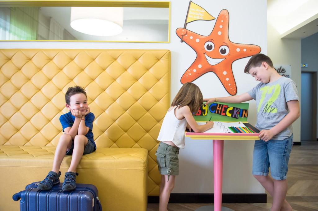Un garçon et une fille debout à côté d'une table dans l'établissement Hotel Fabrizio, à Rimini