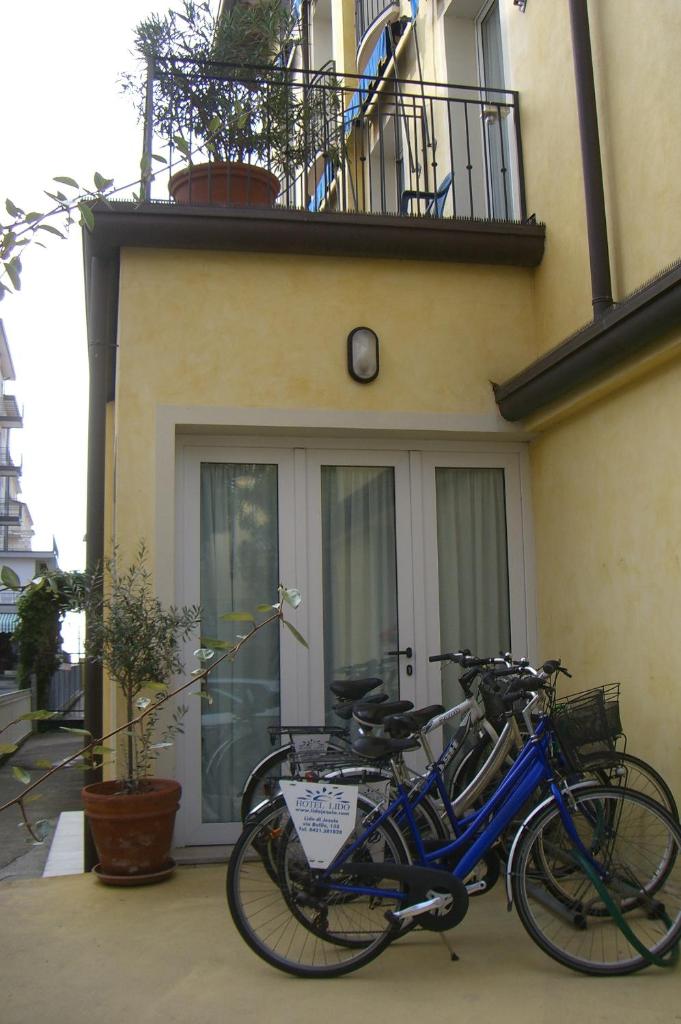 un vélo bleu garé devant un bâtiment dans l'établissement Hotel Lido, à Lido di Jesolo
