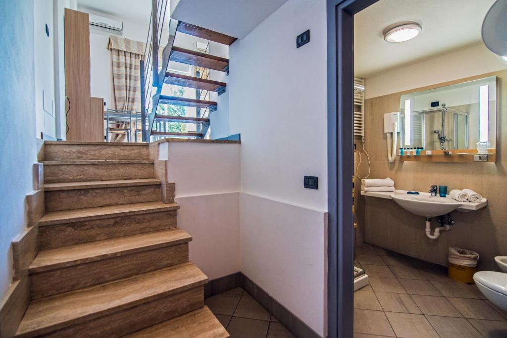 La salle de bains est pourvue d'un escalier, d'un lavabo et de toilettes. dans l'établissement Aregai Marina Hotel & Residence, à Santo Stefano al Mare