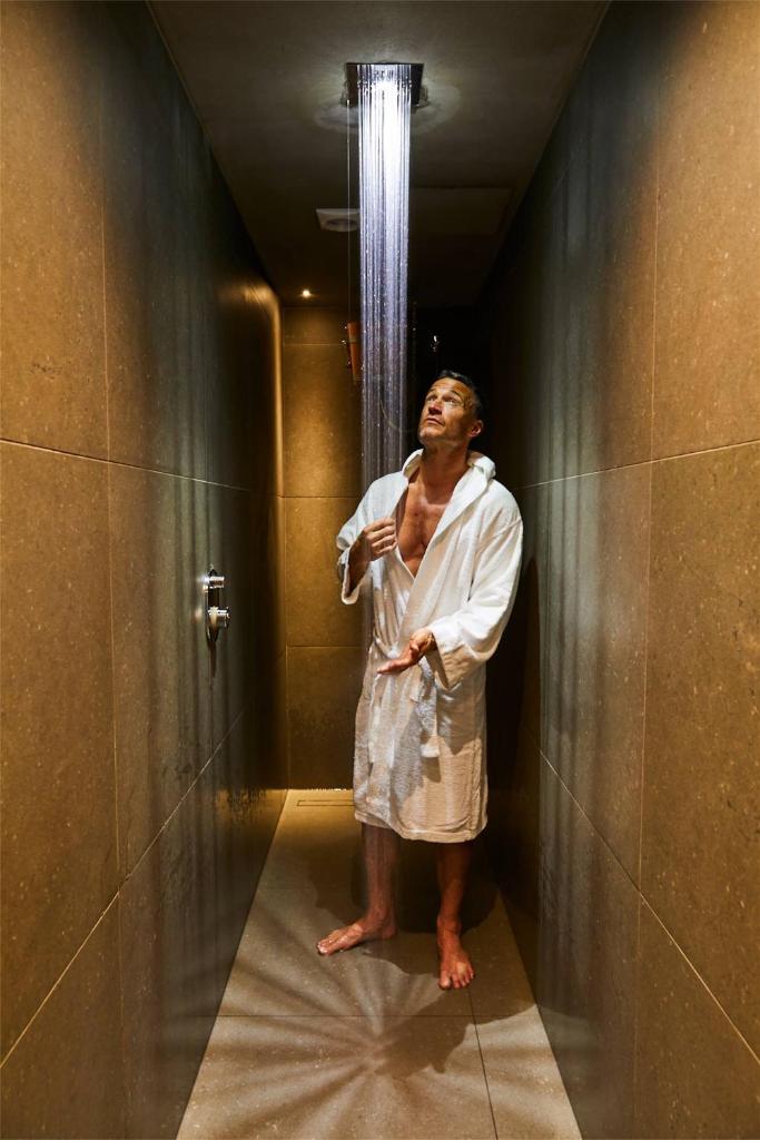 un homme debout dans un couloir dans une douche dans l'établissement Hotel Europa Monetti, à Cattolica