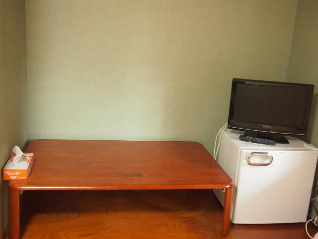 Elle comprend un bureau avec une télévision et un réfrigérateur. dans l'établissement Maetakeso, à Yakushima