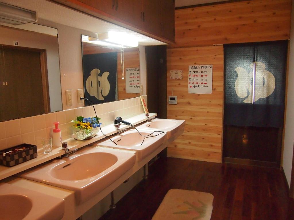 une salle de bain avec deux lavabos et un grand miroir dans l'établissement Maetakeso, à Yakushima