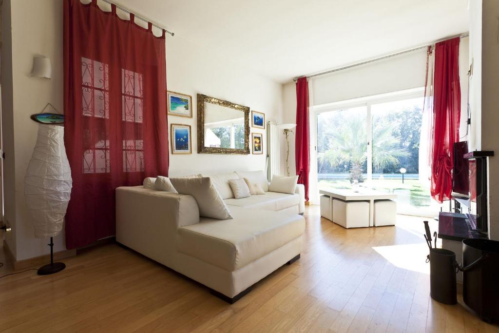 un salon avec un canapé blanc et une grande fenêtre dans l'établissement VILLA DIADEMA, à Vezzi Portio