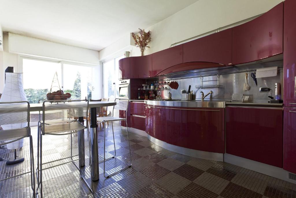 une cuisine avec des armoires rouges et une grande fenêtre dans l'établissement VILLA DIADEMA, à Vezzi Portio