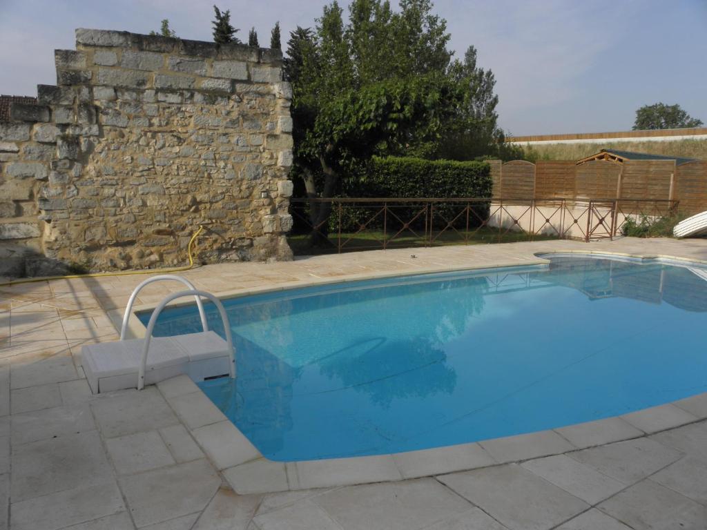 - une piscine dans une cour dotée d'un mur en pierre dans l'établissement Provence Roulottes, à Barbentane