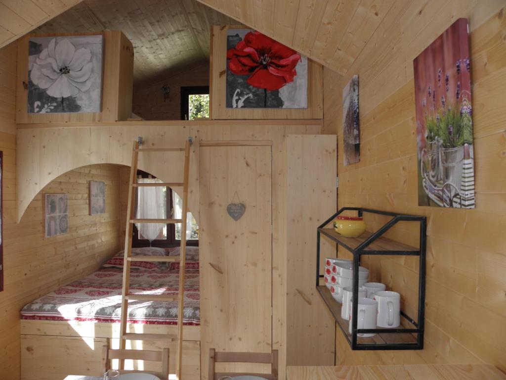 Cette chambre comprend un lit dans une cabane en bois. dans l'établissement Provence Roulottes, à Barbentane
