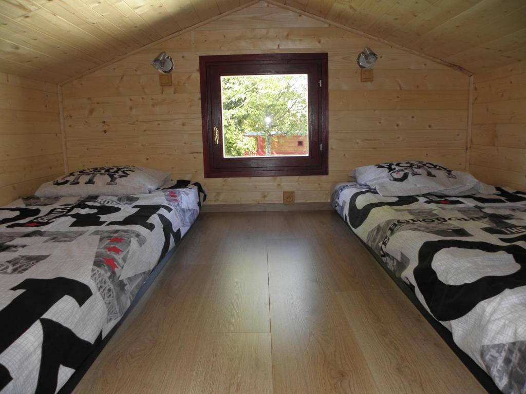 - 2 lits dans une cabane en rondins avec fenêtre dans l'établissement Provence Roulottes, à Barbentane
