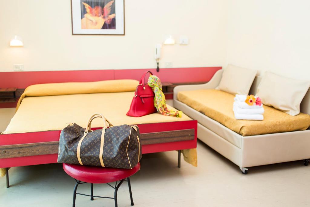 une chambre avec deux lits et une chaise avec un sac à main dans l'établissement Hotel Garden, à Riccione 48 autres photos