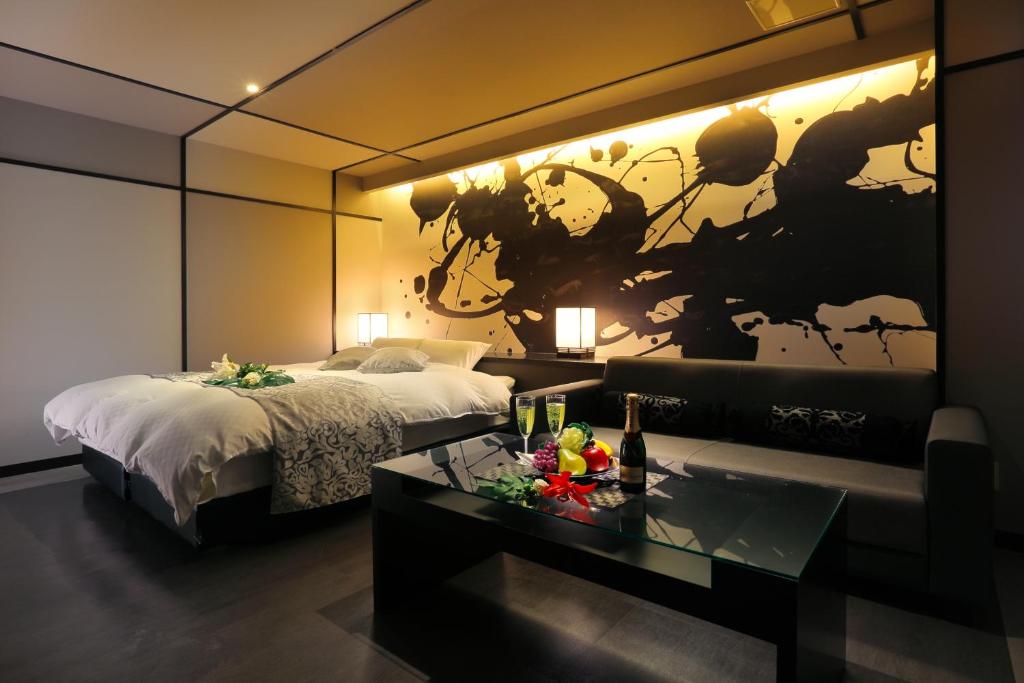 - une chambre d'hôtel avec un lit et une table avec un sidx dans l'établissement HOTEL 小粋 -coiki-, à Hiroshima