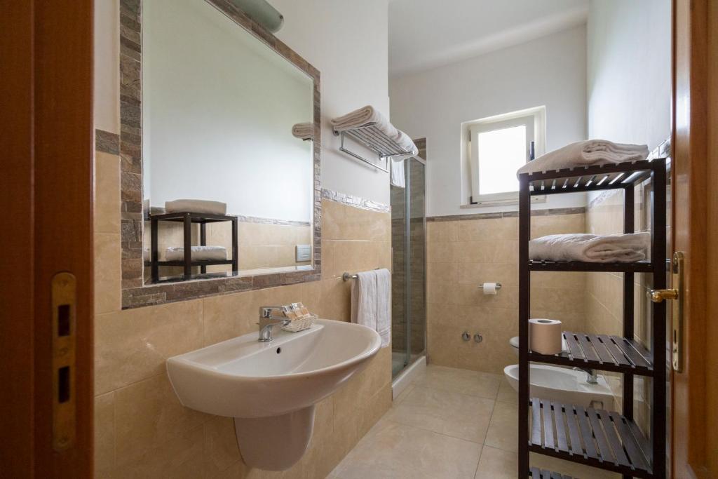 une salle de bain avec un lavabo et un miroir et des toilettes dans l'établissement Villaggio Passo Dell'Arciprete, à Vieste