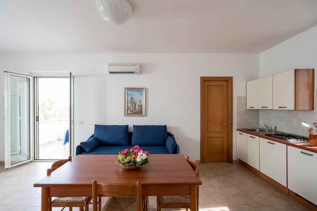 un salon avec un canapé bleu et une table dans l'établissement Villaggio Passo Dell'Arciprete, à Vieste