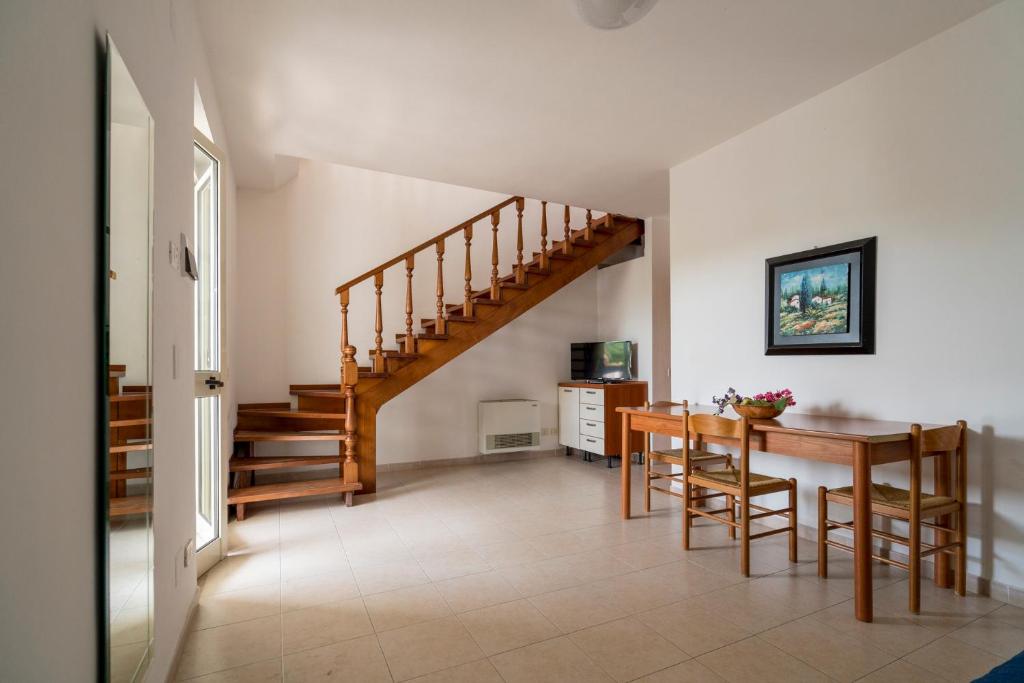 - un salon avec une table en bois et un escalier dans l'établissement Villaggio Passo Dell'Arciprete, à Vieste