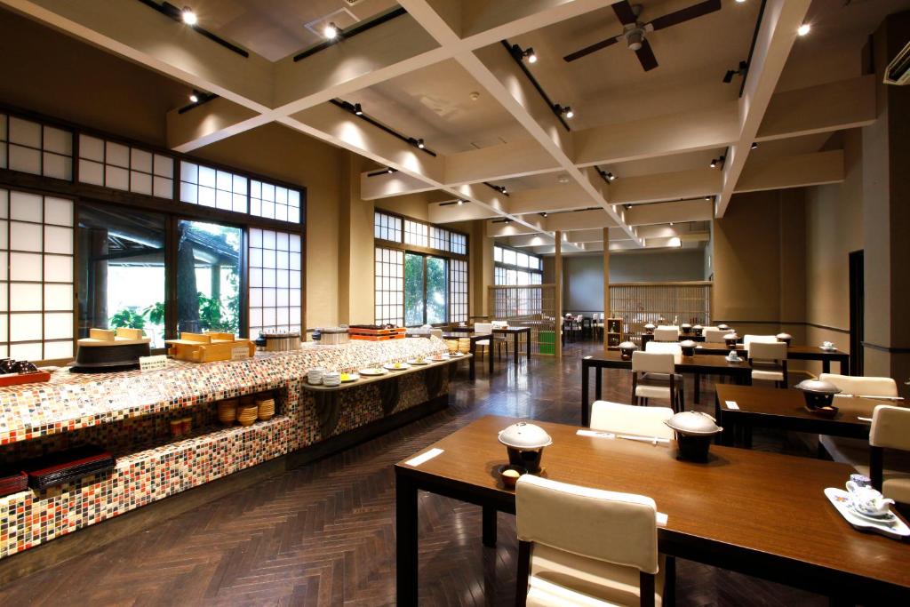 un restaurant avec des tables, des chaises et des fenêtres dans l'établissement Sozankyo, à Aso