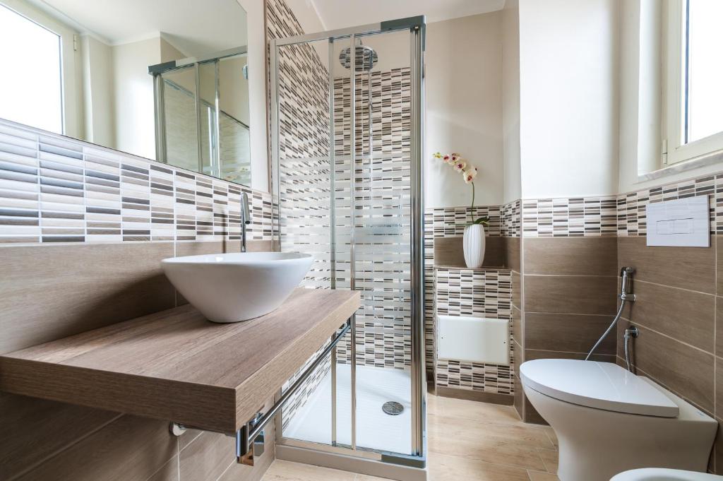 une salle de bain avec un lavabo, des toilettes et une douche dans l'établissement Albergo Elea, à Ascea