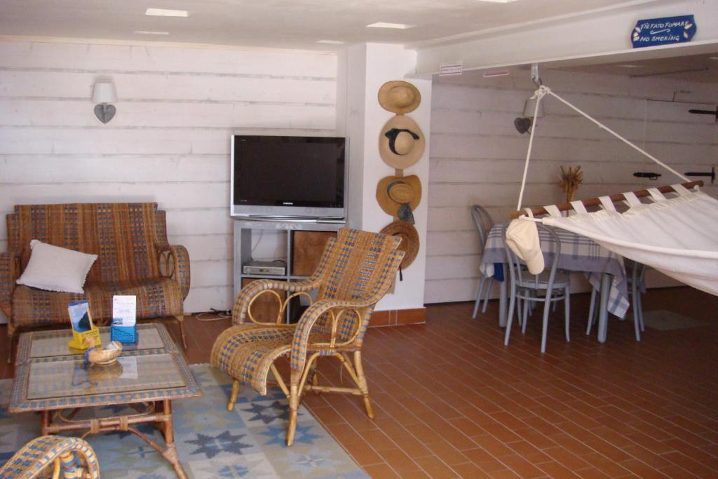 d'un salon avec des chaises en osier et une télévision à écran plat. dans l'établissement Hotel Helios, à Santa Margherita Ligure