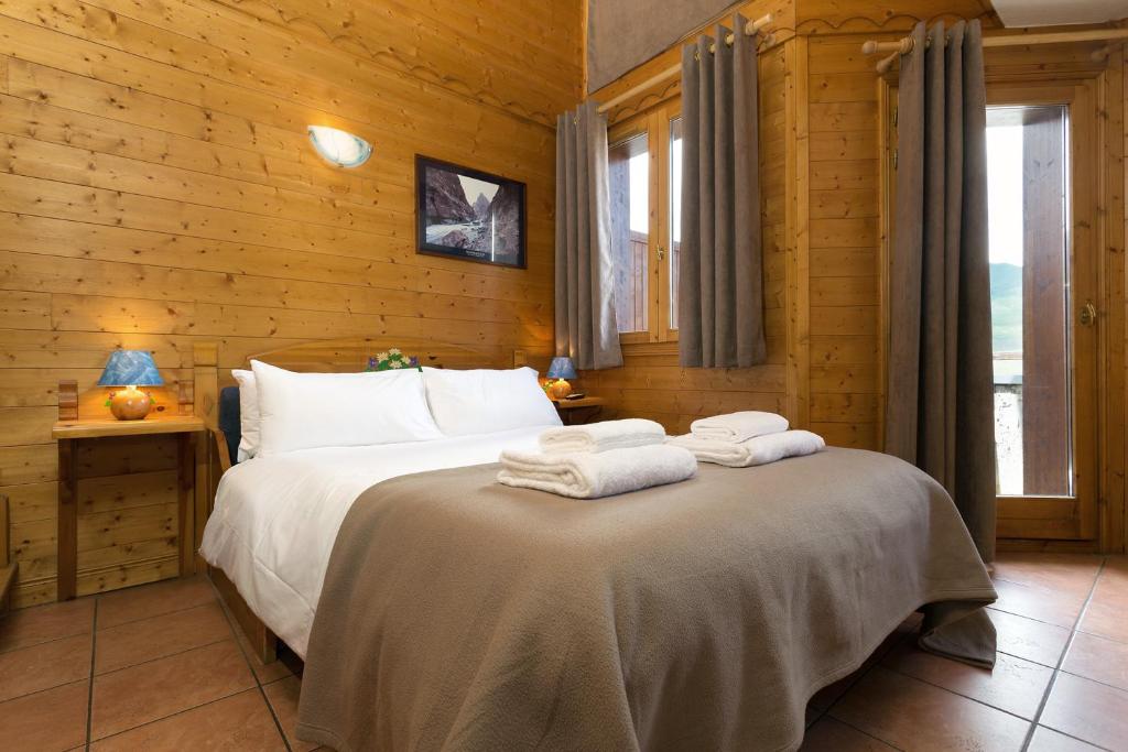 une chambre avec un lit avec des serviettes dessus dans l'établissement Madame Vacances Lodges des Alpages, à La Plagne