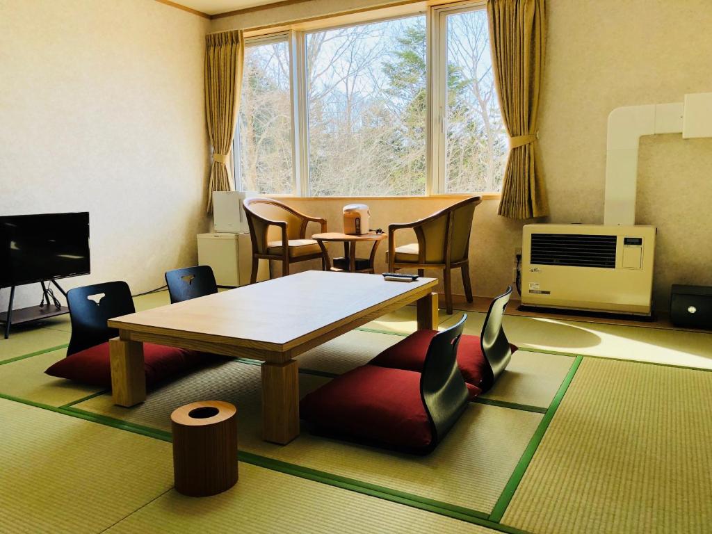 un salon avec une table et des chaises dans l'établissement Kurplaza Pirika, à Hanaishi