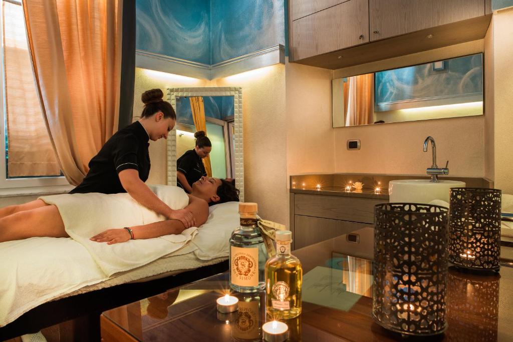 une femme dormant dans un lit dans une pièce dans l'établissement Hotel Ligure, à Alassio