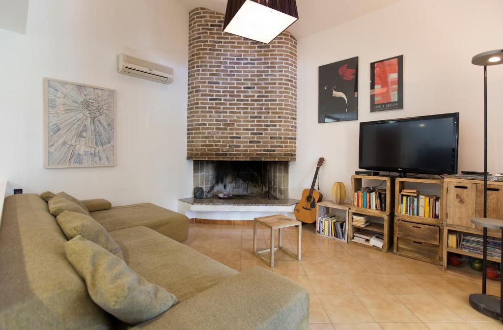 un salon avec un canapé et une cheminée dans l'établissement villa sara, à Alghero