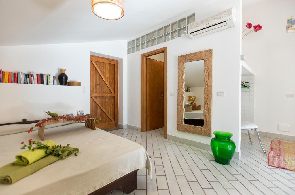 une chambre avec un lit et un miroir dans l'établissement villa sara, à Alghero