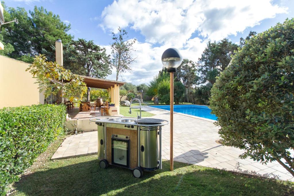 - un barbecue extérieur éclairé à côté de la piscine dans l'établissement villa sara, à Alghero