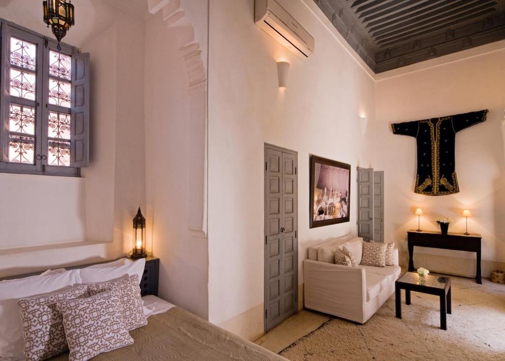 - une chambre avec un lit et une croix sur le mur dans l'établissement Riad Dar Hanane, à Marrakech