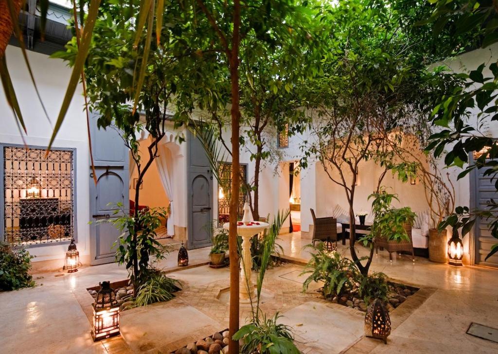une cour avec des arbres et des lumières dans un bâtiment dans l'établissement Riad Dar Hanane, à Marrakech