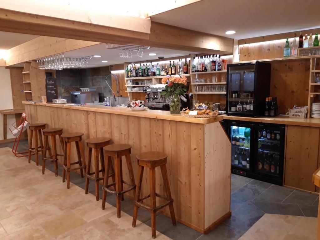 un bar dans un restaurant avec tabourets à un comptoir dans l'établissement Le Relais Nordique, à Giron