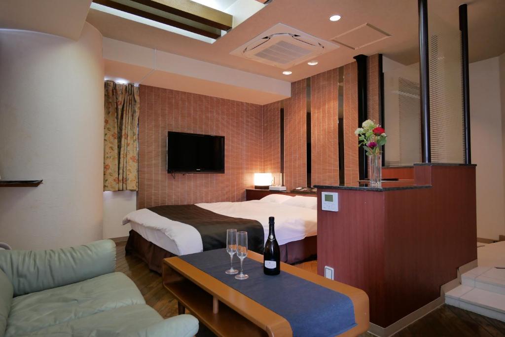une chambre d'hôtel avec un lit et une table avec des verres à vin dans l'établissement Hotel ACQUA MYU, à Fukuoka
