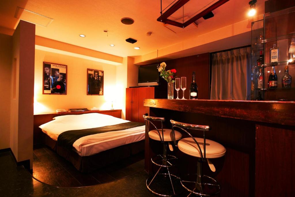 une chambre d'hôtel avec un lit et un bar dans l'établissement Hotel ACQUA MYU, à Fukuoka