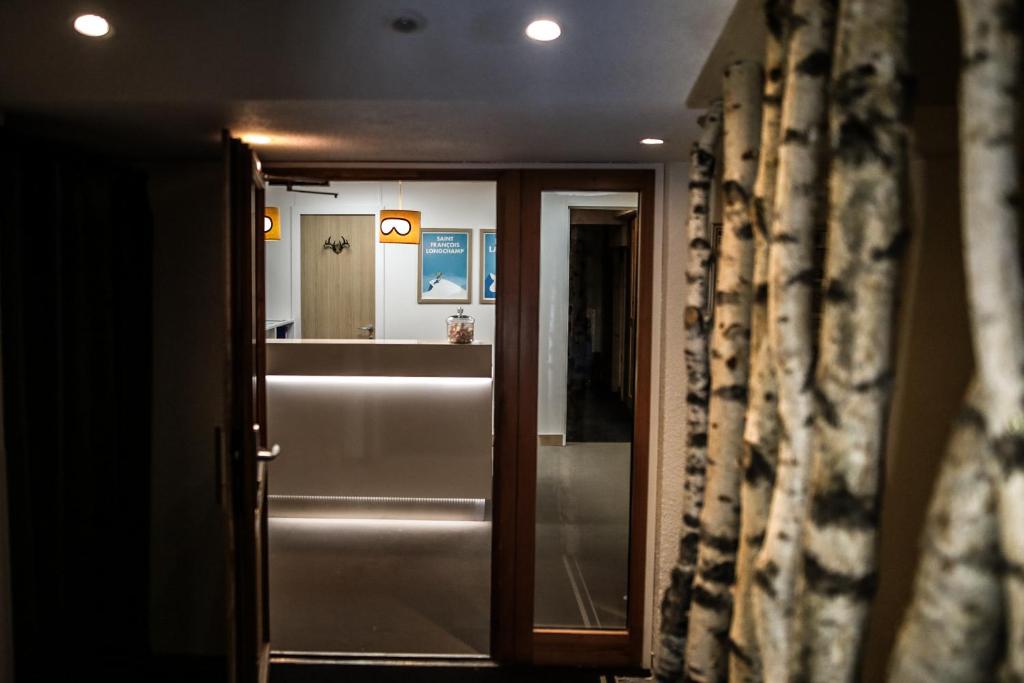 - un couloir avec une porte et un miroir dans la chambre dans l'établissement Hotel Lac Bleu 1650, à Saint-François-Longchamp