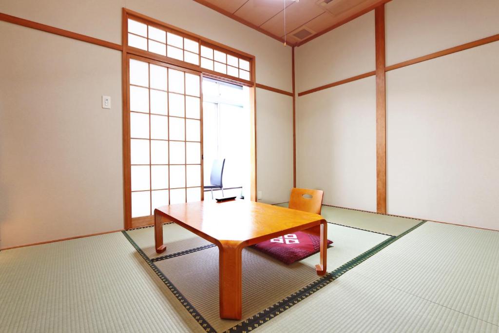 une pièce avec une table, une chaise et une fenêtre dans l'établissement Ebisusou, à Takashima