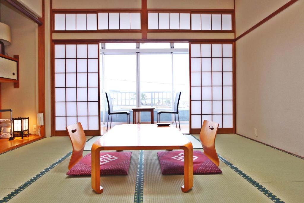 un salon avec une table et des chaises dans une pièce dans l'établissement Ebisusou, à Takashima