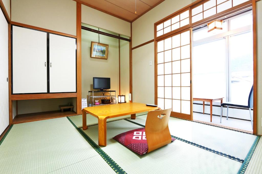 d'un salon avec une table en bois et des fenêtres. dans l'établissement Ebisusou, à Takashima 5 autres photos