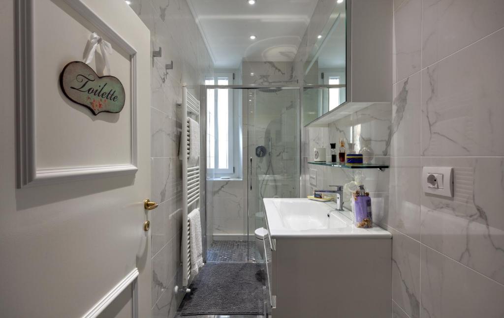 une salle de bain blanche avec un lavabo et une douche dans l'établissement Villa La Dolce Vita, à Oliveto Lario