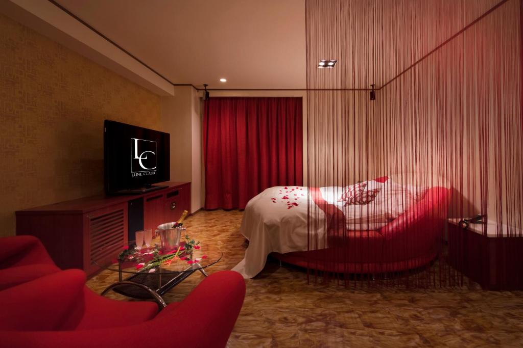 une chambre d'hôtel avec un lit et une chaise rouge dans l'établissement Hotel LUNE CLAIRE (Adult Only), à Chikuma