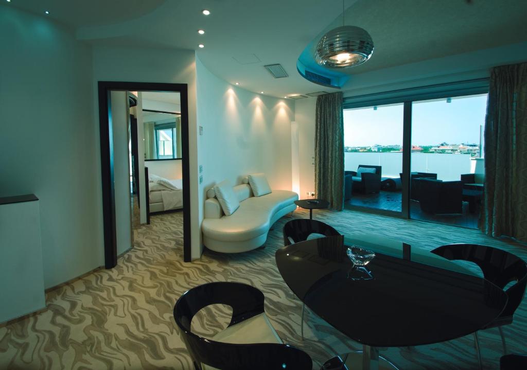 Cette chambre d'hôtel dispose d'un salon avec vue sur l'eau. dans l'établissement Hotel Premier & Suites - Premier Resort, à Milano Marittima