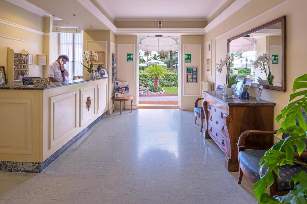 Un homme debout à un comptoir dans une pièce dans l'établissement Hotel Paradiso, à Sanremo 100 autres photos