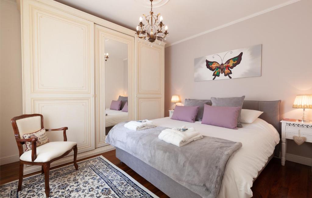 - une chambre avec un lit, une chaise et un lustre dans l'établissement Villa La Dolce Vita, à Oliveto Lario