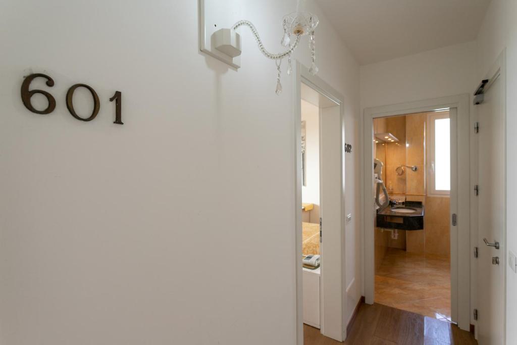 un couloir avec un numéro de maison sur le mur dans l'établissement Hotel Panama, à Lido di Jesolo