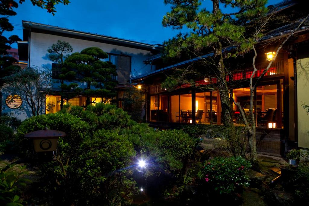 une maison la nuit avec des lumières allumées dans l'établissement Ryokan Sennari (13 years or older), à Beppu