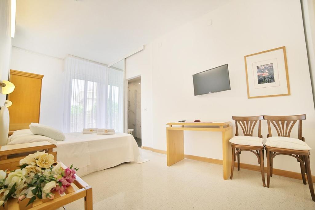 une chambre avec un lit, une table et des chaises dans l'établissement Hotel Pinocchio, à Cattolica