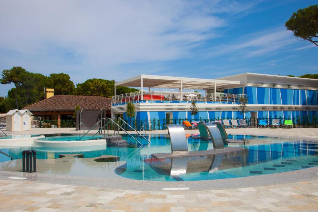 - une piscine avec des chaises en face d'un bâtiment dans l'établissement The Green Park Hotel WellnessSpa & Restaurant, à Cavallino-Treporti