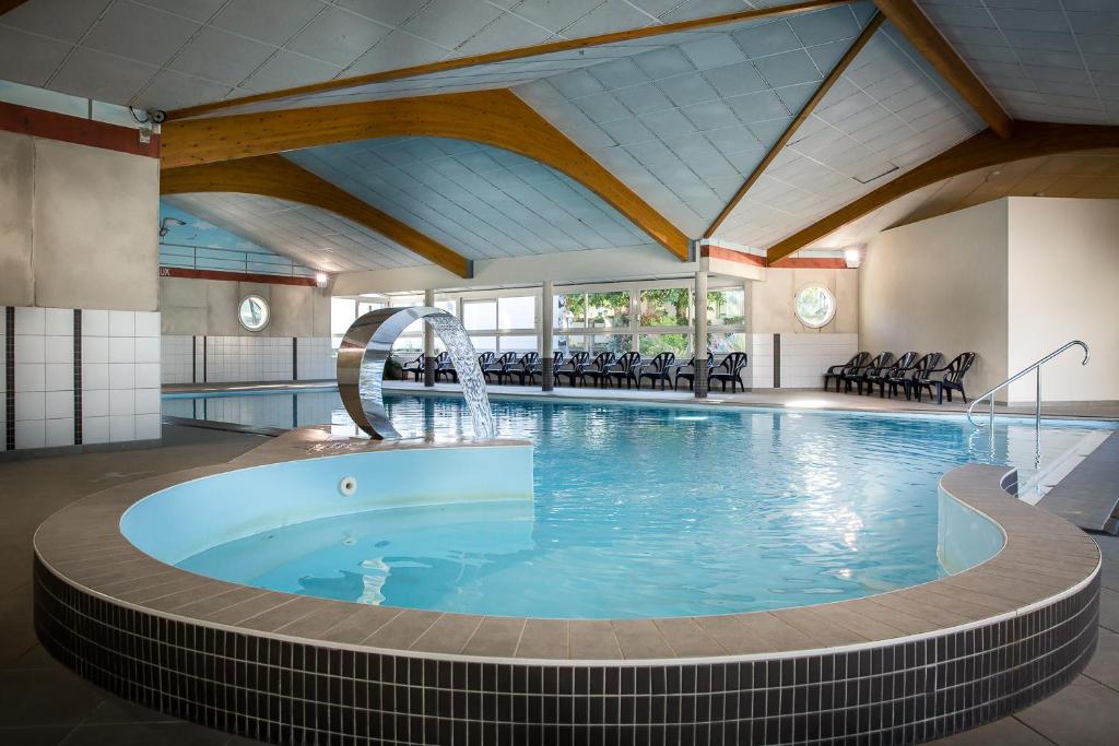 - une grande piscine avec une fontaine dans un bâtiment dans l'établissement Camping l'Ile aux Oiseaux, à LʼÎle-dʼOlonne