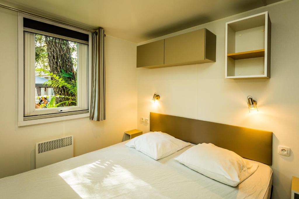 une chambre avec un lit et une fenêtre dans l'établissement Camping la Sousta****, à Remoulins